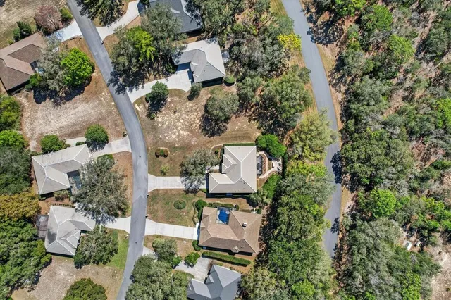 an aerial view of residential houses with outdoor space and a lake view