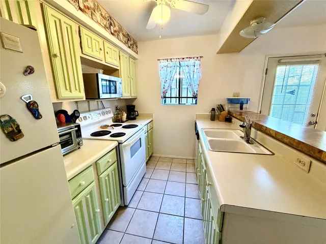 a kitchen with a sink a stove top oven a counter space and a window