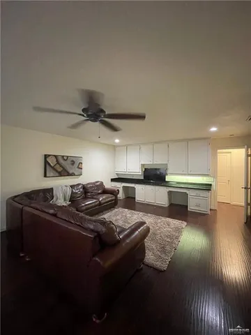 a large kitchen with kitchen island a stove a sink dishwasher and white cabinets with wooden floor