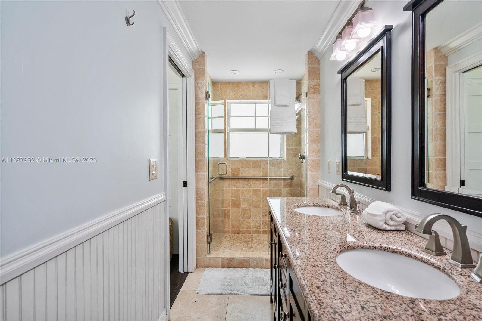 2533 Northeast 21st Terrace Lighthouse Point, FL 33064 - Photo 23 of 45 a bathroom with a granite countertop sink a mirror and a shower