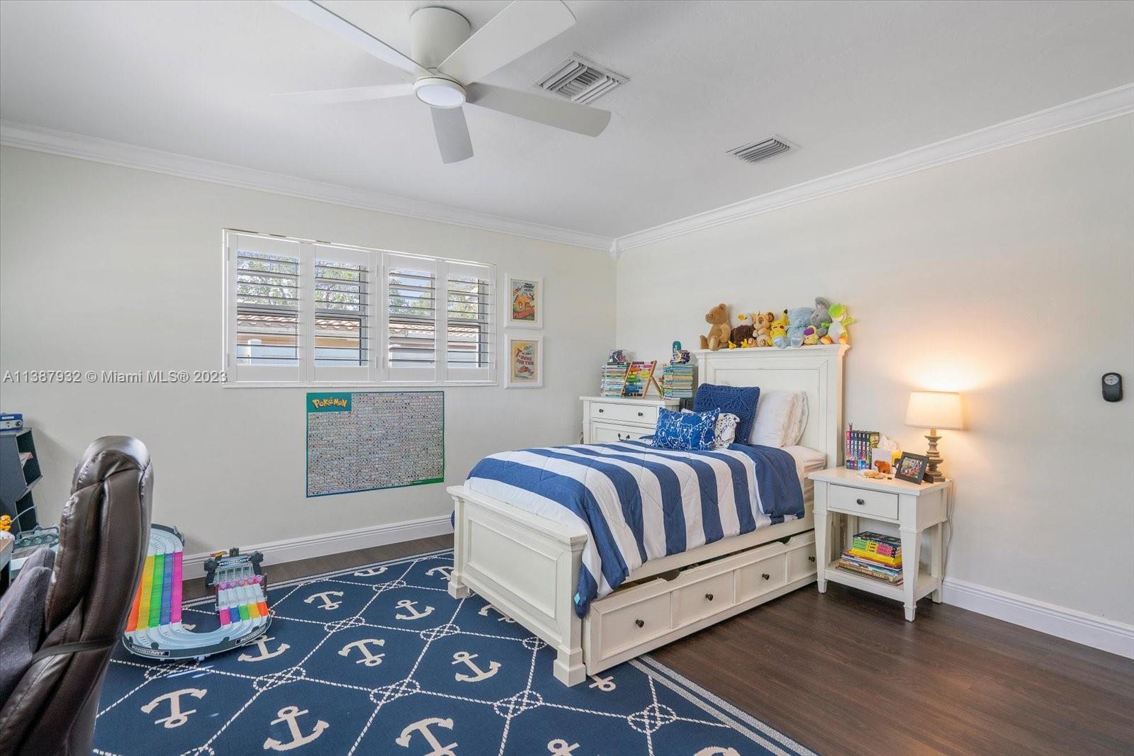2533 Northeast 21st Terrace Lighthouse Point, FL 33064 - Photo 26 of 45 a bedroom with a bed and a chandelier