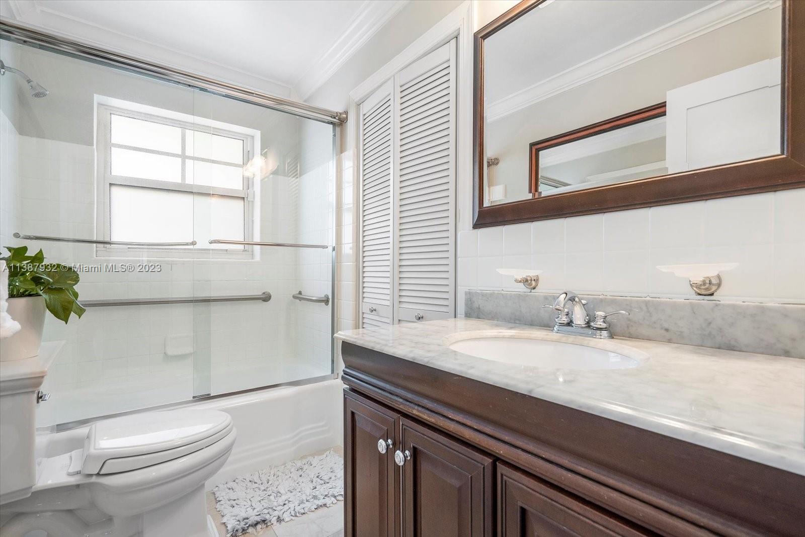 2533 Northeast 21st Terrace Lighthouse Point, FL 33064 - Photo 28 of 45 a bathroom with a granite countertop sink a toilet and a window
