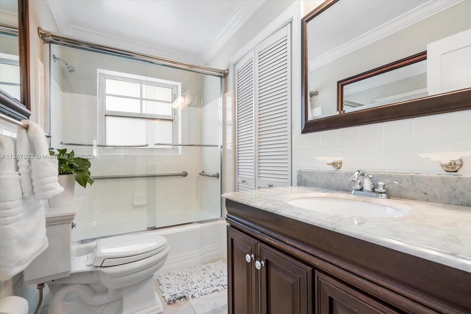 2533 Northeast 21st Terrace Lighthouse Point, FL 33064 - Photo 29 of 45 a bathroom with a granite countertop sink a toilet a mirror and shower