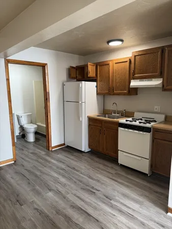 a kitchen with a sink a refrigerator and a stove top oven