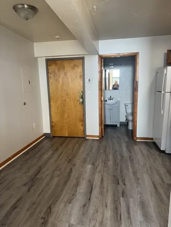 a view of a room with wooden floor and a bathroom