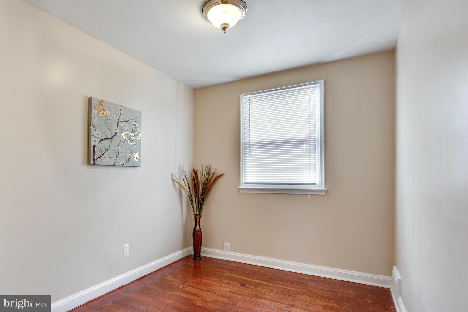 1701 Burnwood Road Baltimore, MD 21239 - Photo 19 of 30 an empty room with wooden floor and windows