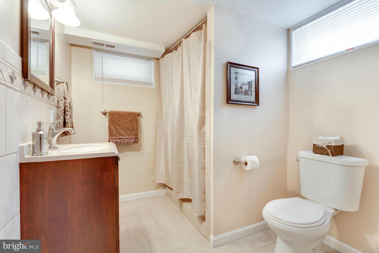 1701 Burnwood Road Baltimore, MD 21239 - Photo 24 of 30 a bathroom with a toilet sink and mirror