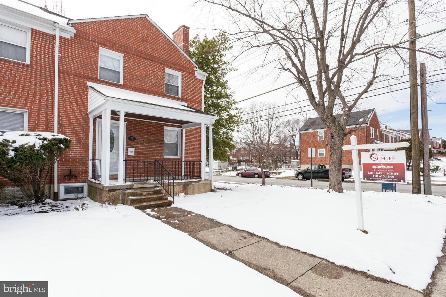 1701 Burnwood Road Baltimore, MD 21239 - Photo 29 of 30 a view of a brick house with a yard covered in snow