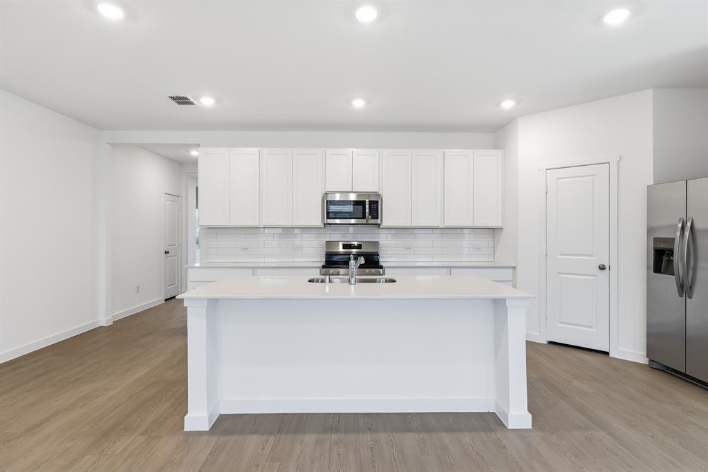 4916 Ascot Way Princeton, TX 75407 - Photo 11 of 39 a kitchen with stainless steel appliances granite countertop a stove a sink and a refrigerator