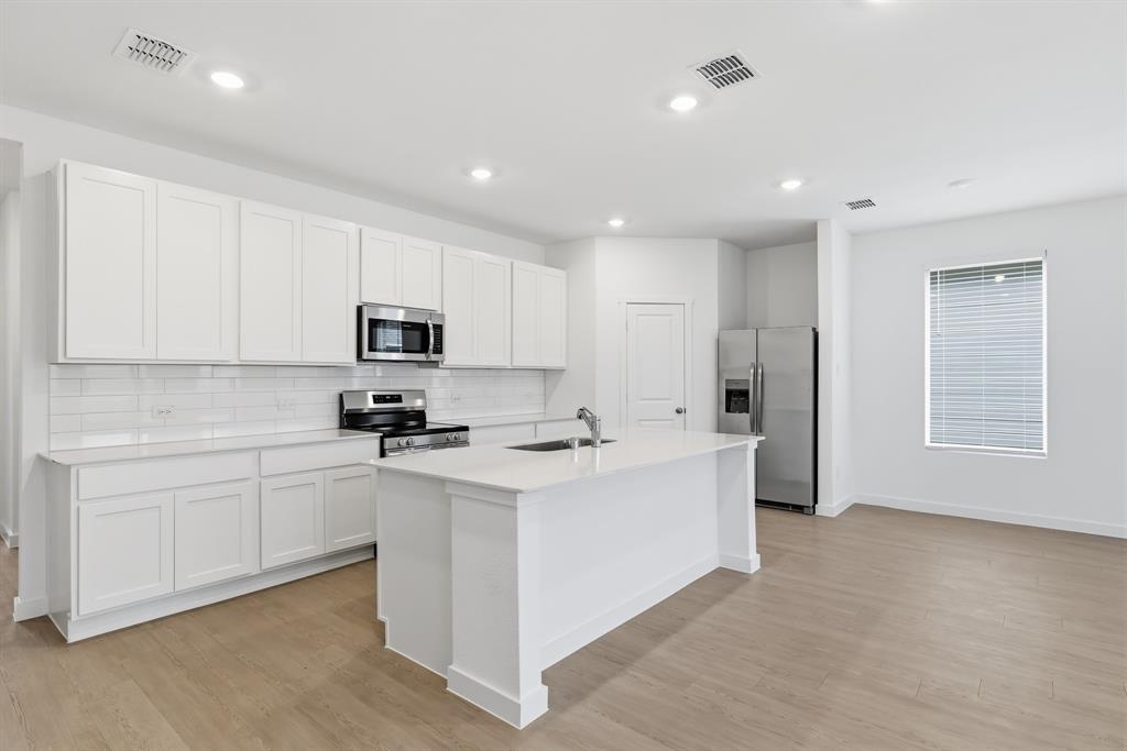 4916 Ascot Way Princeton, TX 75407 - Photo 12 of 39 a kitchen with stainless steel appliances a stove a sink a refrigerator a white cabinets and a refrigerator