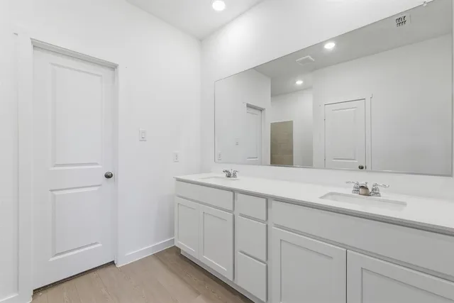 a bathroom with a double vanity sink and mirror