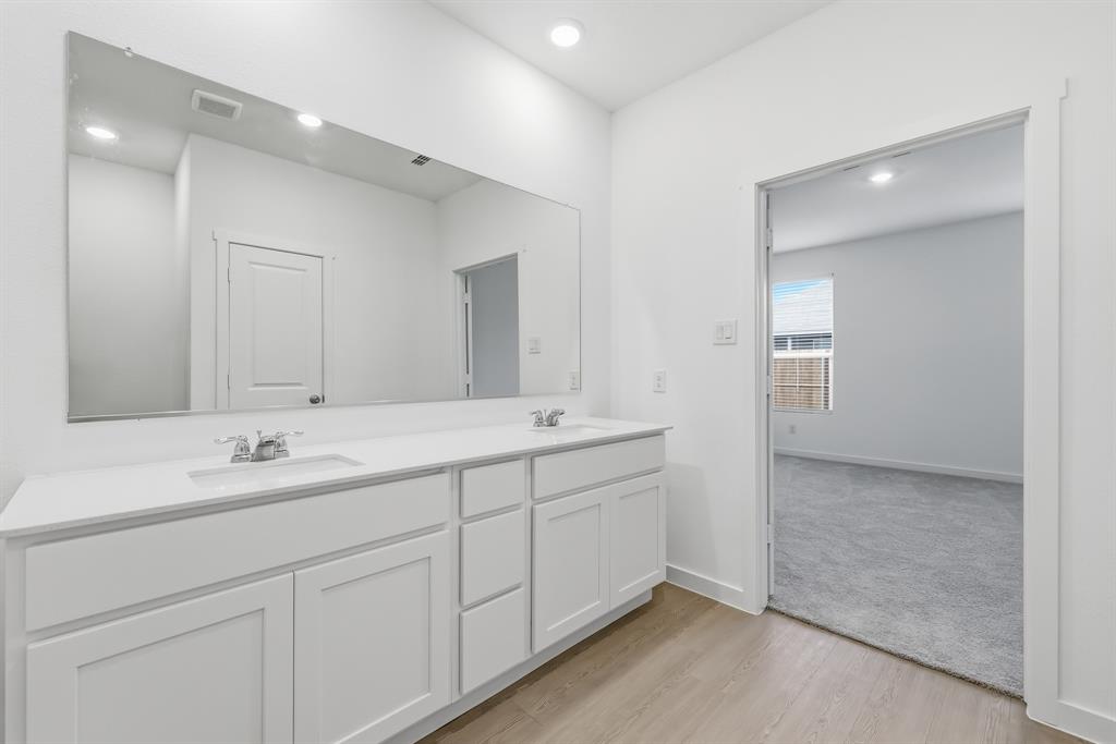 4916 Ascot Way Princeton, TX 75407 - Photo 22 of 39 a bathroom with double sink and a mirror