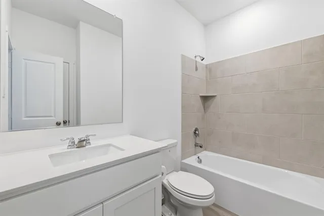 a bathroom with a granite countertop sink a toilet and shower