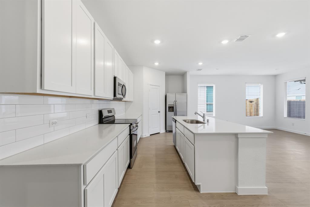 4916 Ascot Way Princeton, TX 75407 - Photo 6 of 39 a large kitchen with stainless steel appliances granite countertop a lot of counter space and wooden floor