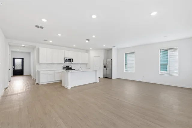 a view of kitchen with white cabinets and stainless steel appliances