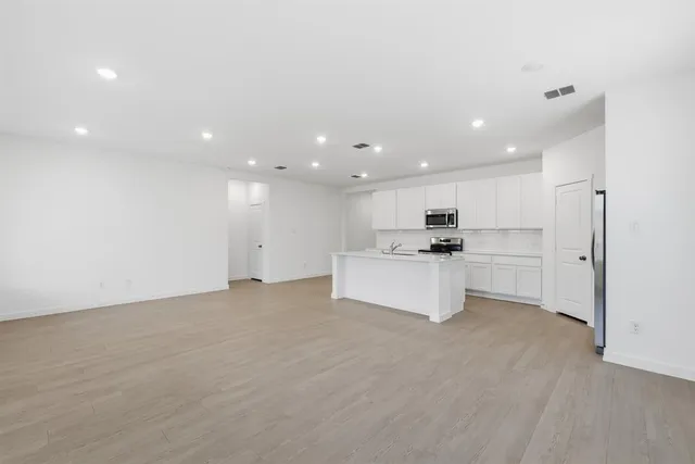 a view of kitchen with kitchen island white cabinets and refrigerator