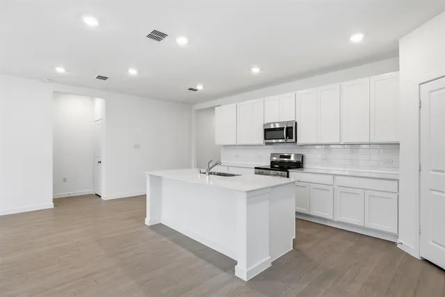 a kitchen with stainless steel appliances granite countertop a stove and a refrigerator