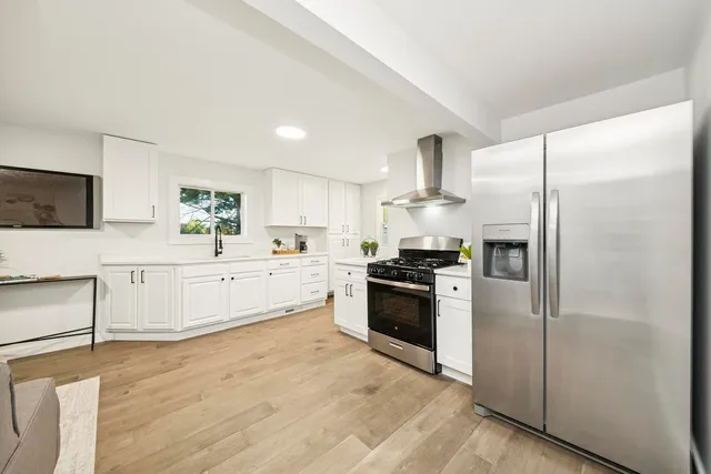 a kitchen with stainless steel appliances a refrigerator sink and microwave