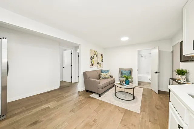 a living room with furniture and a wooden floor