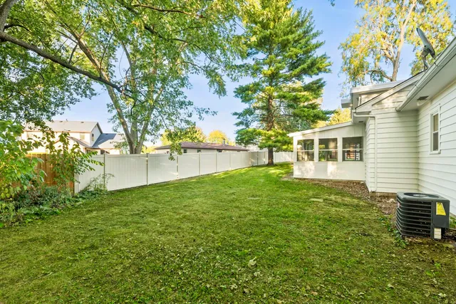 a view of a backyard with plants and large trees