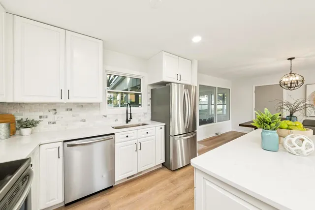 a kitchen with a refrigerator and white cabinets