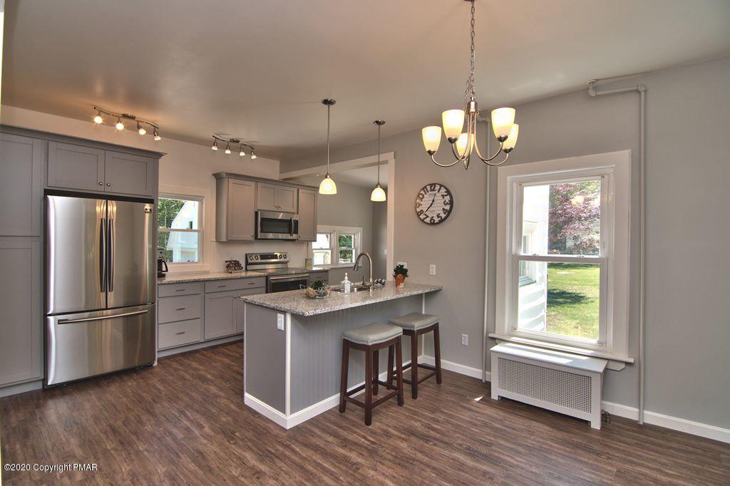 362 Upper Swiftwater Road Cresco, PA 18326 - Photo 13 of 87 a kitchen with stainless steel appliances granite countertop a refrigerator a sink dishwasher a dining table and chairs with wooden floor