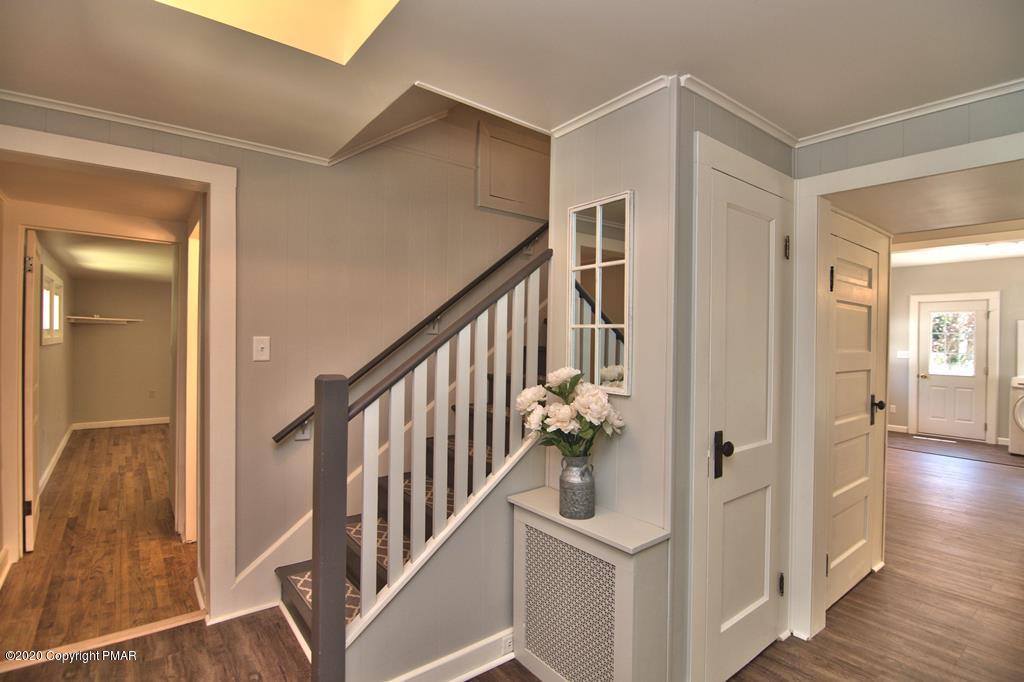362 Upper Swiftwater Road Cresco, PA 18326 - Photo 6 of 87 a view of an entryway with wooden floor leading to a furnished livingroom and floor to ceiling windows
