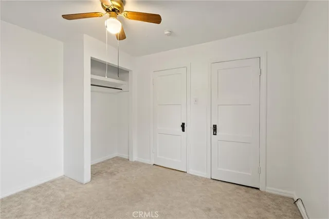 an empty room with a ceiling fan and window
