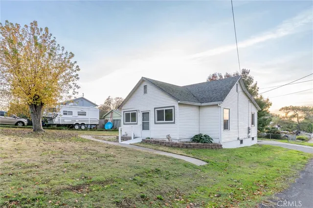 a view of a house with a big yard and large trees