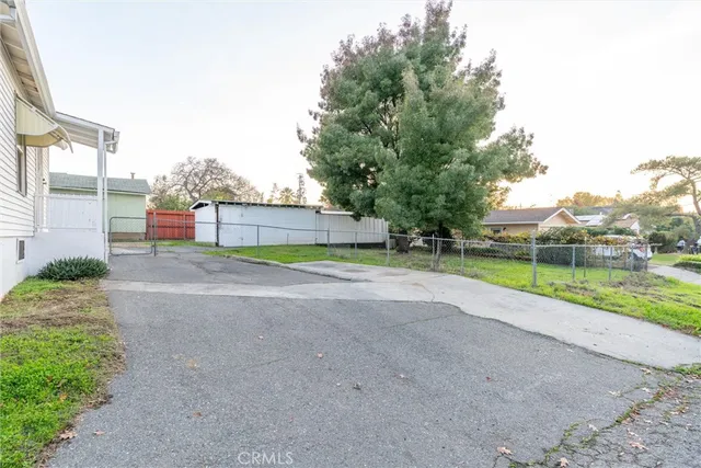 a view of a backyard with a house and a large tree
