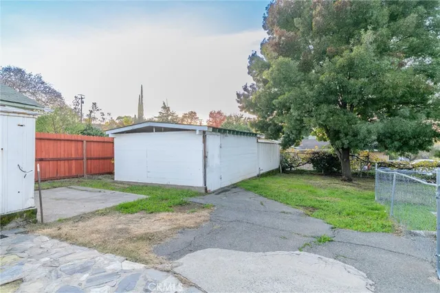a view of a house with backyard and trees