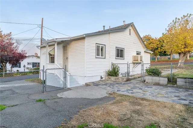 a front view of a house with a yard and trees