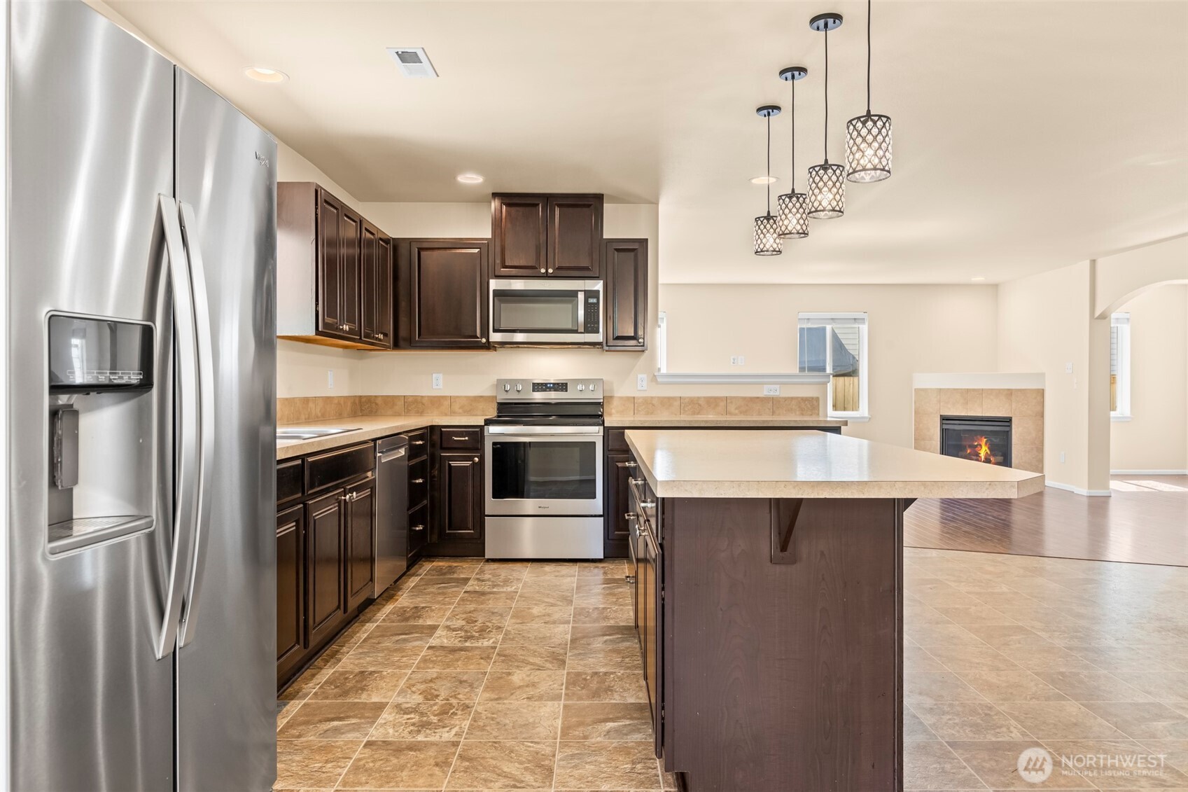 1408 Daffodil Avenue Northeast Orting, WA 98360 - Photo 3 of 37 a kitchen with stainless steel appliances granite countertop a refrigerator and a stove top oven