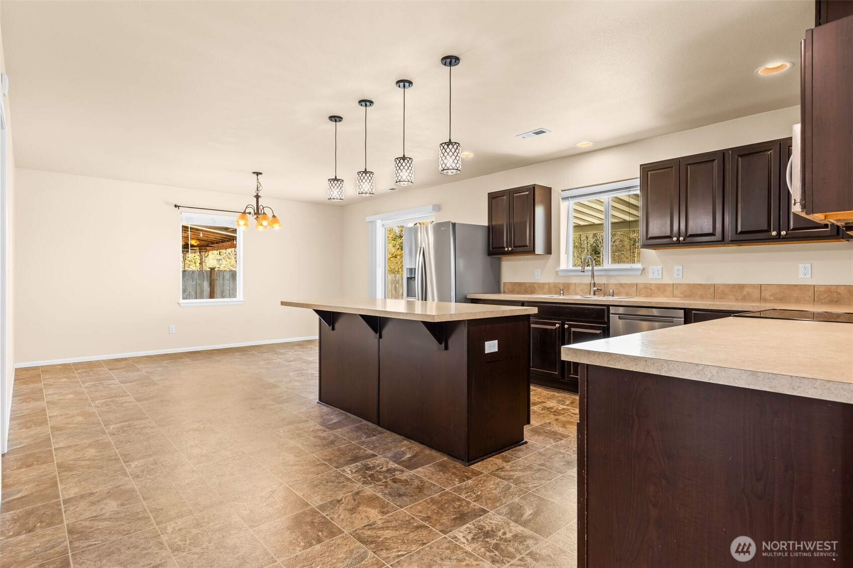 1408 Daffodil Avenue Northeast Orting, WA 98360 - Photo 4 of 37 a kitchen with stainless steel appliances granite countertop a sink a stove and a refrigerator