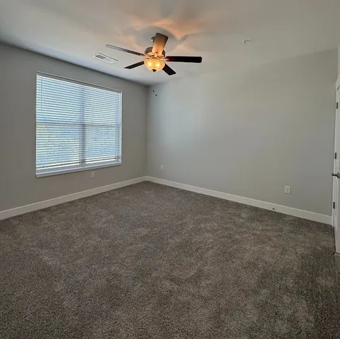 a view of an empty room and a ceiling fan