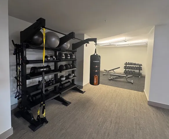 a room with gym equipment and large mirror