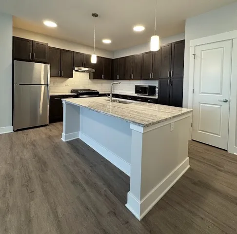 an empty room with wooden floor and entryway