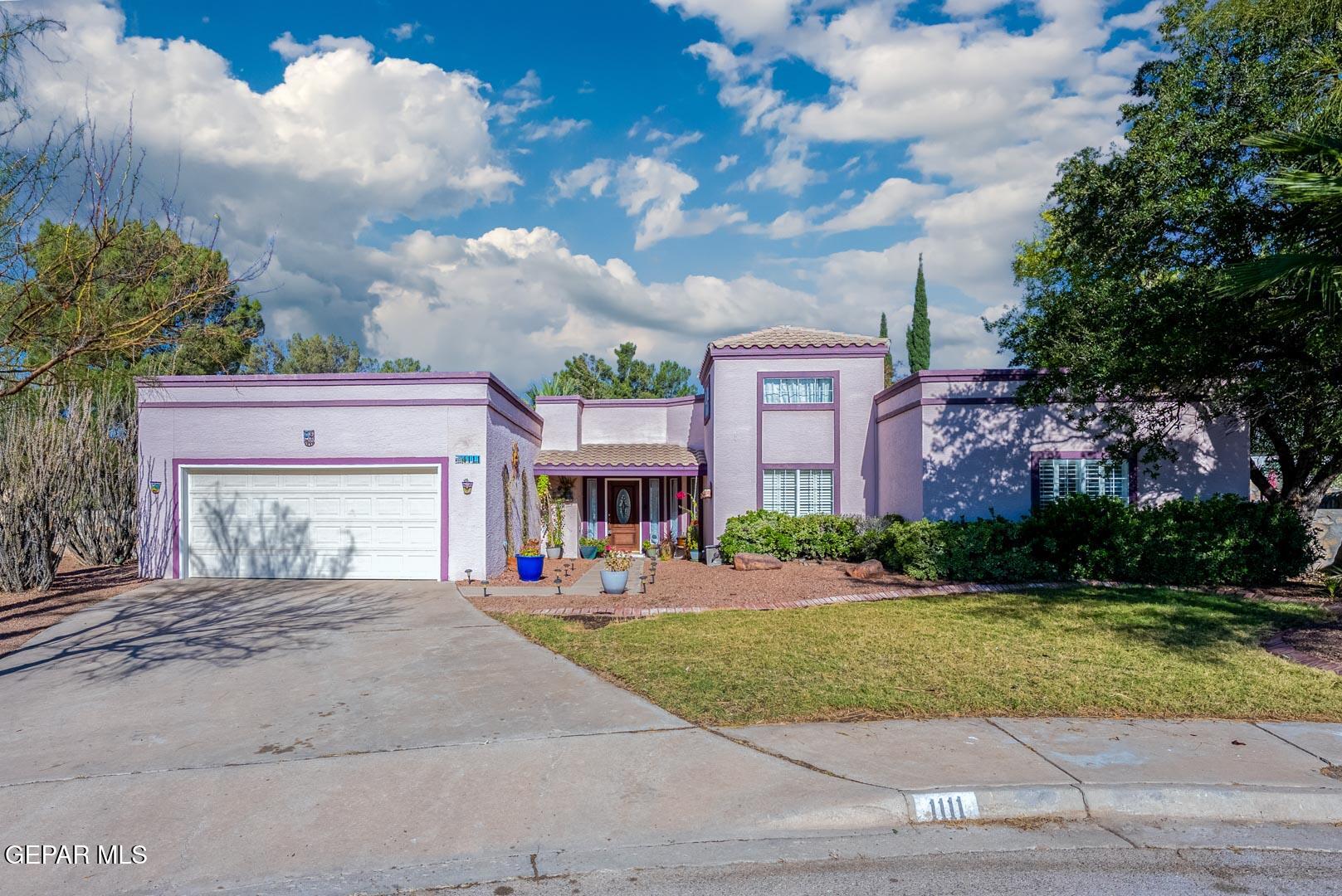 a front view of a house with yard and green space