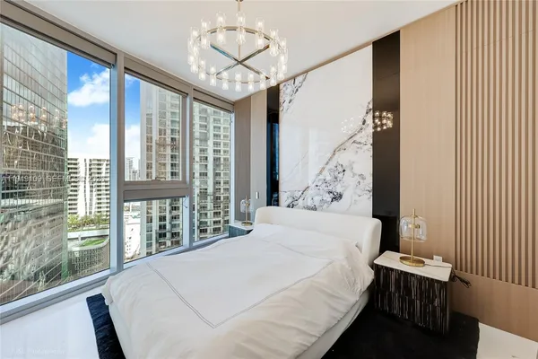 a bedroom with a large bed and a large window