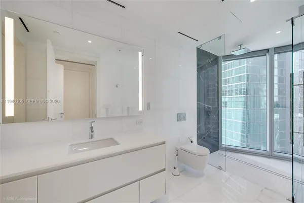 a bathroom with a double vanity sink toilet and shower