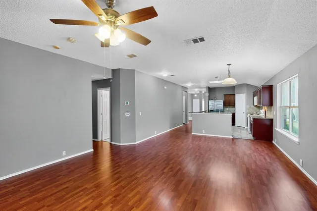 a view of a kitchen with wooden floor and a ceiling fan