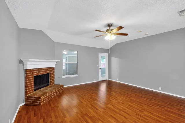 a view of empty room with a fireplace and a chandelier fan