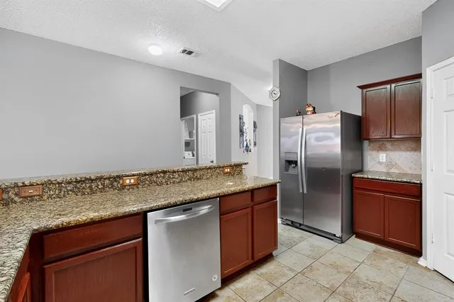 a kitchen with stainless steel appliances granite countertop a refrigerator and a sink