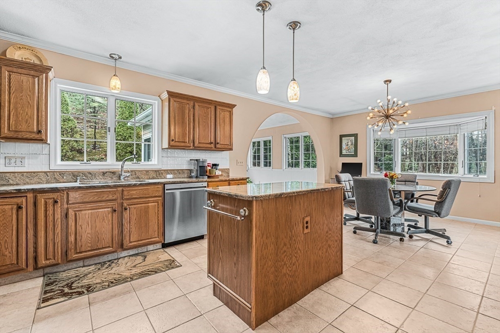 71 Hammersmith Drive Saugus, MA 01906 - Photo 12 of 41 a kitchen with granite countertop wooden cabinets a dining table and chairs