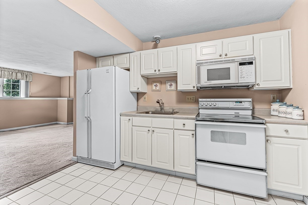 71 Hammersmith Drive Saugus, MA 01906 - Photo 34 of 41 a kitchen with granite countertop white cabinets and white appliances