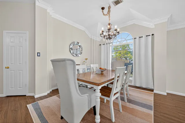 a view of a dining room with furniture wooden floor and chandelier