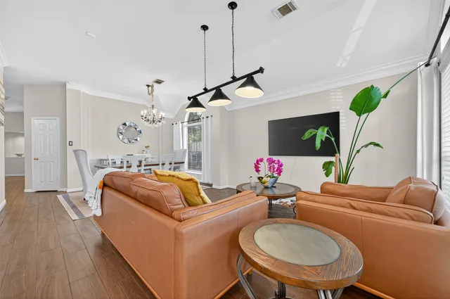 a living room with furniture a chandelier and a flat screen tv