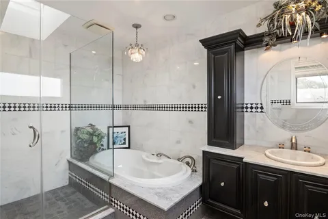 a bathroom with a tub sink and mirror