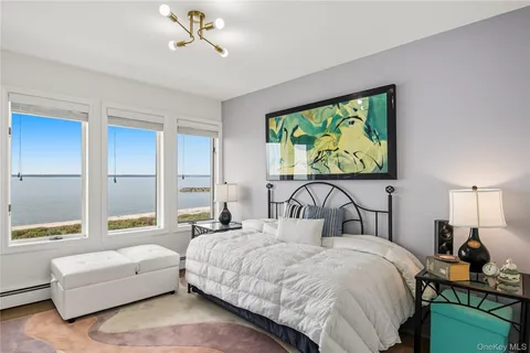 a bedroom with a bed mirror and window