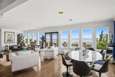 a living room with furniture kitchen view and large windows